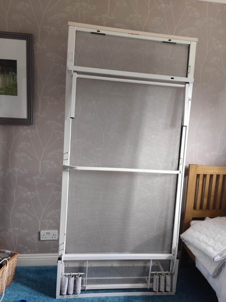 Single wall bed folds vertically against wall
