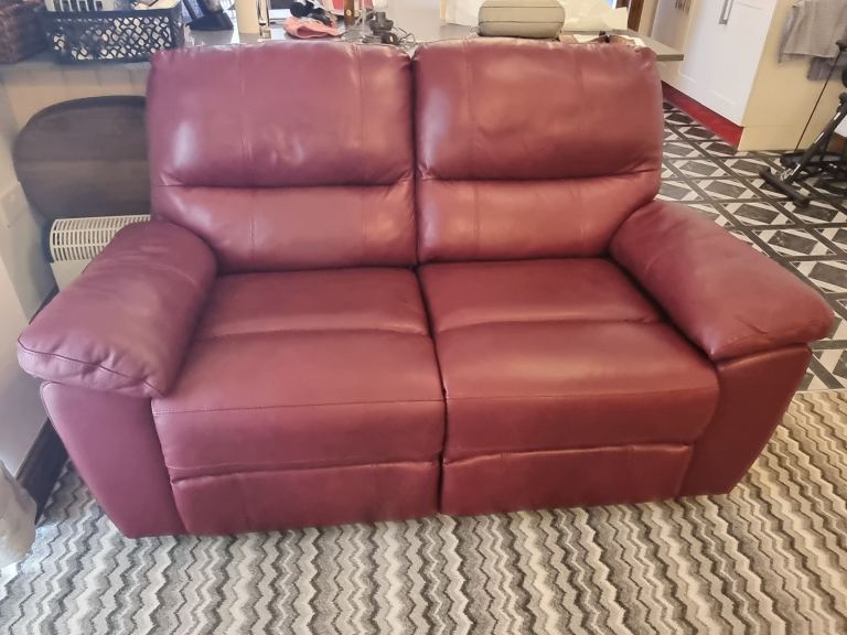 A Pair of red leather electric reclining sofas