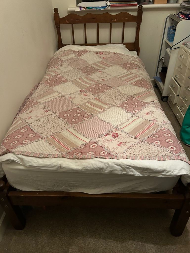 Wooden single bed with slatted base.