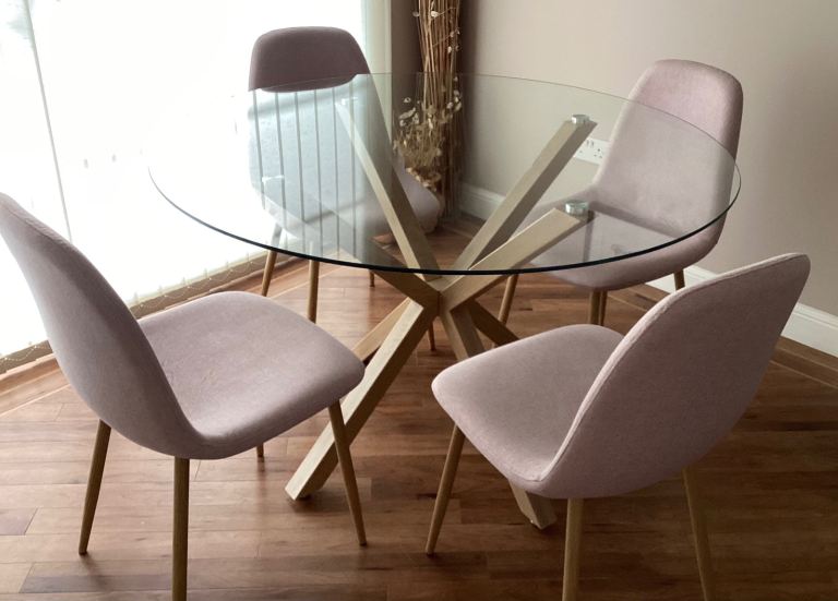 Dining table with glass top and four dining chairs.