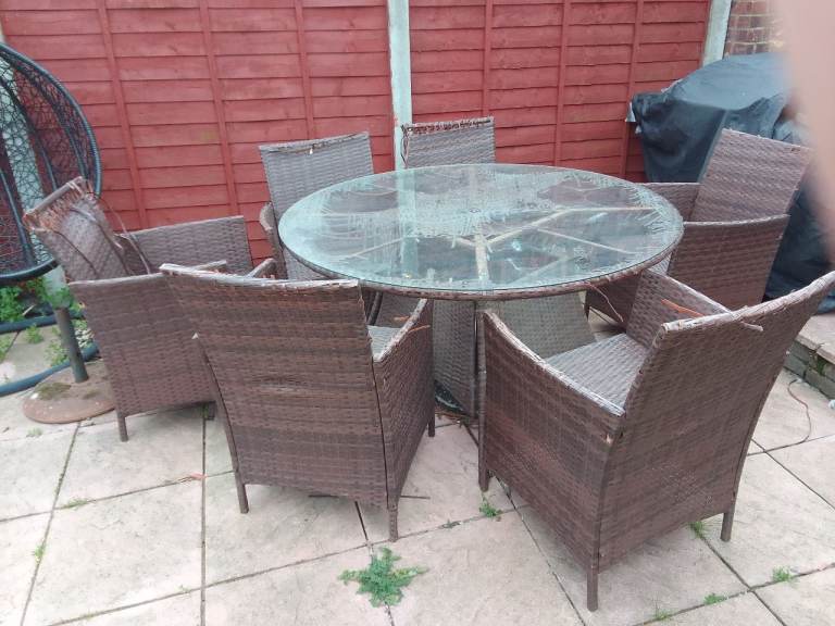 Brown garden ratten set with 6 chairs and a round glass table (with hole for parasol).