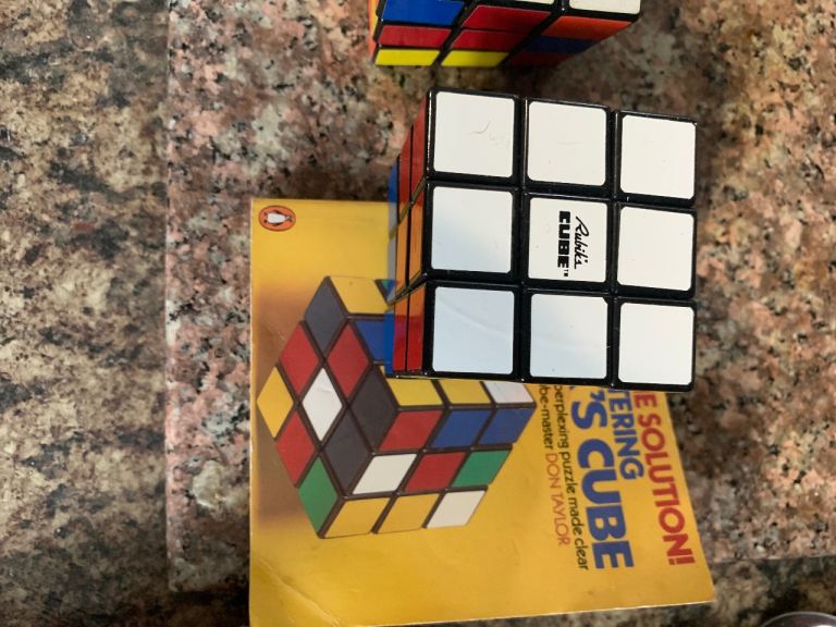 Two vintage Rubix cubes with cheat books