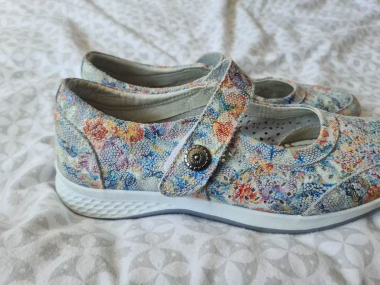 Pair of comfy leather flat shoes with a pretty floral pattern in various colours.