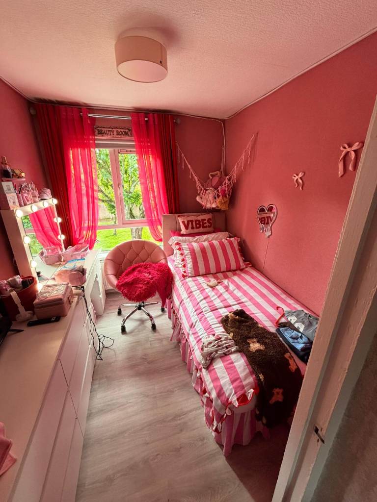 Single Bed with Striped Bedding and Pink Office Chair
