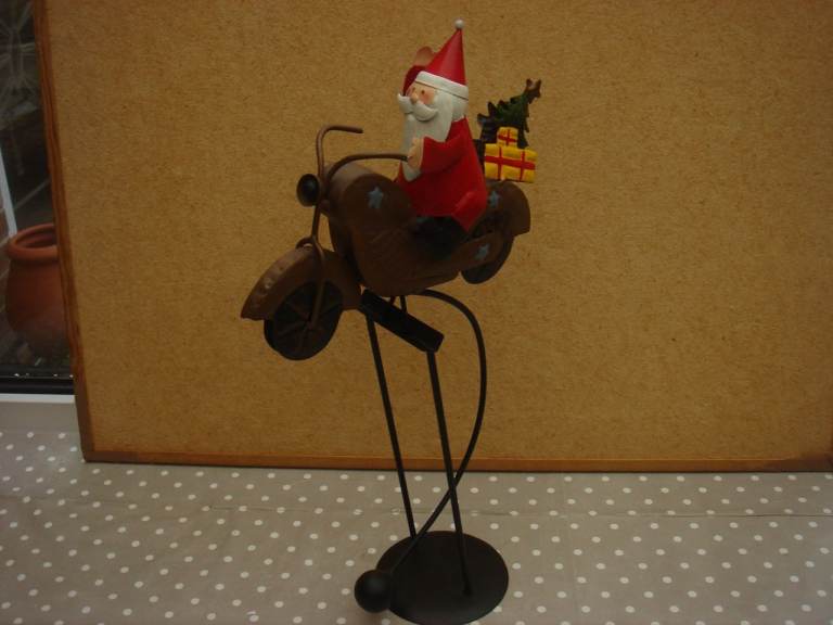 METAL SANTA ON SWINGING MOTORBIKE. 