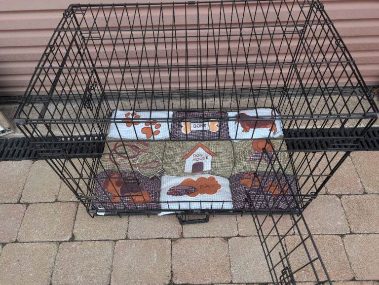 Black metal dog crate with patterned bedding