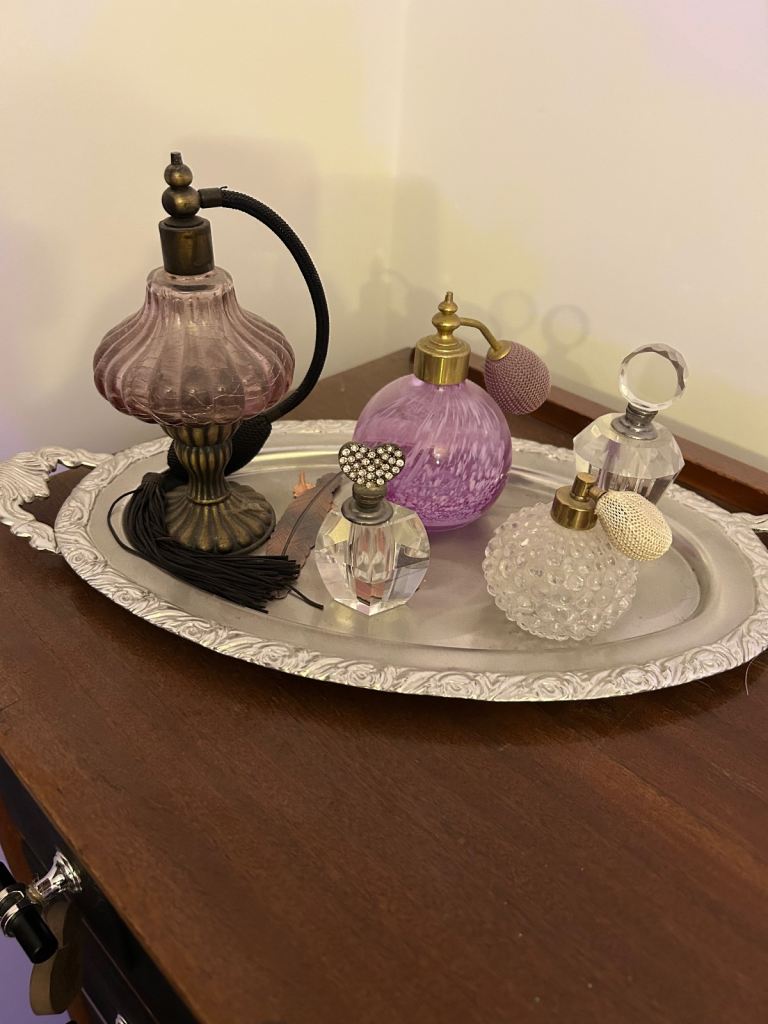 Selection decorative perfume bottles on silver tray. 