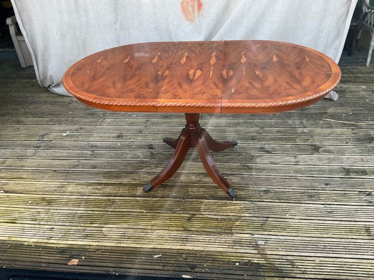 A Bowling reproduction dining table in yew grain