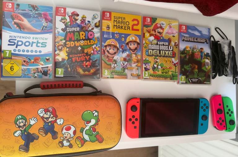Nintendo Switch (Neon Red/Blue), extra controller, and 5-game bundle.