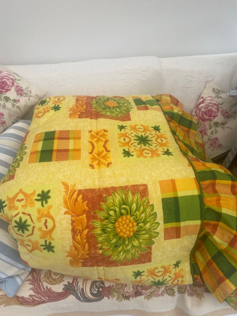 Quilted throw over sunflower bedspread 