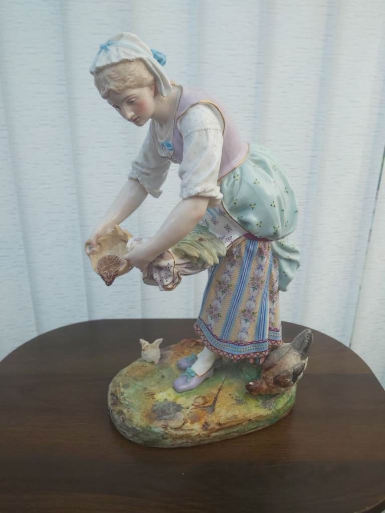 Large china figurine of a girl feeding Chickens