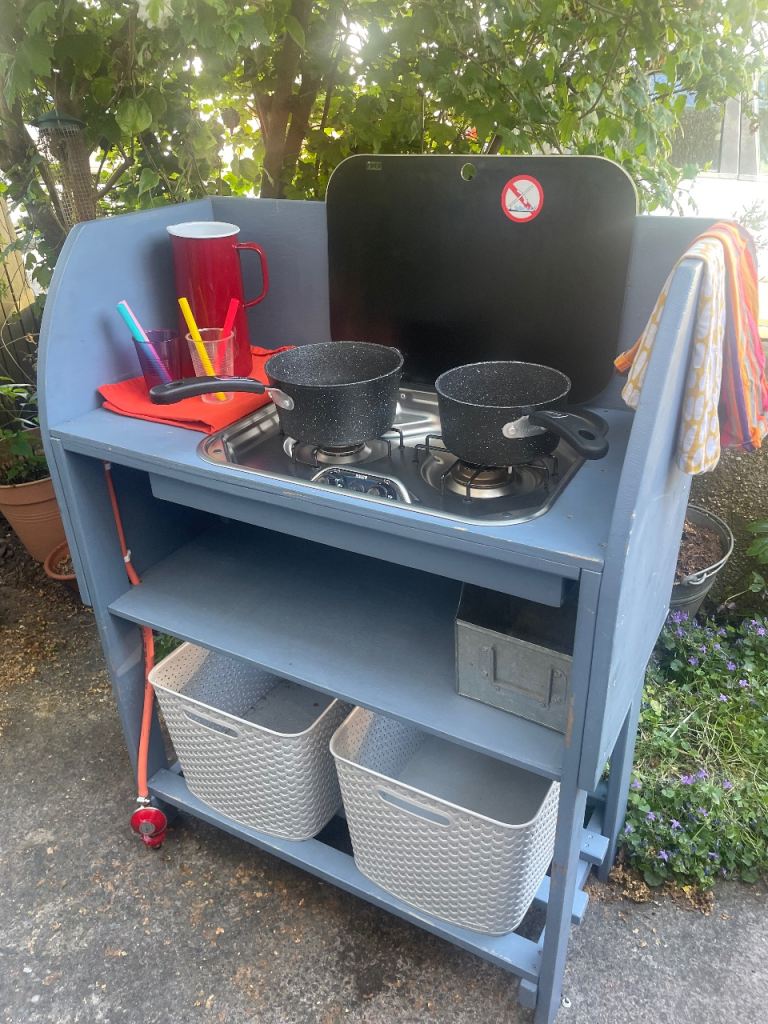 Camping kitchen with double gas burner and propane bottle