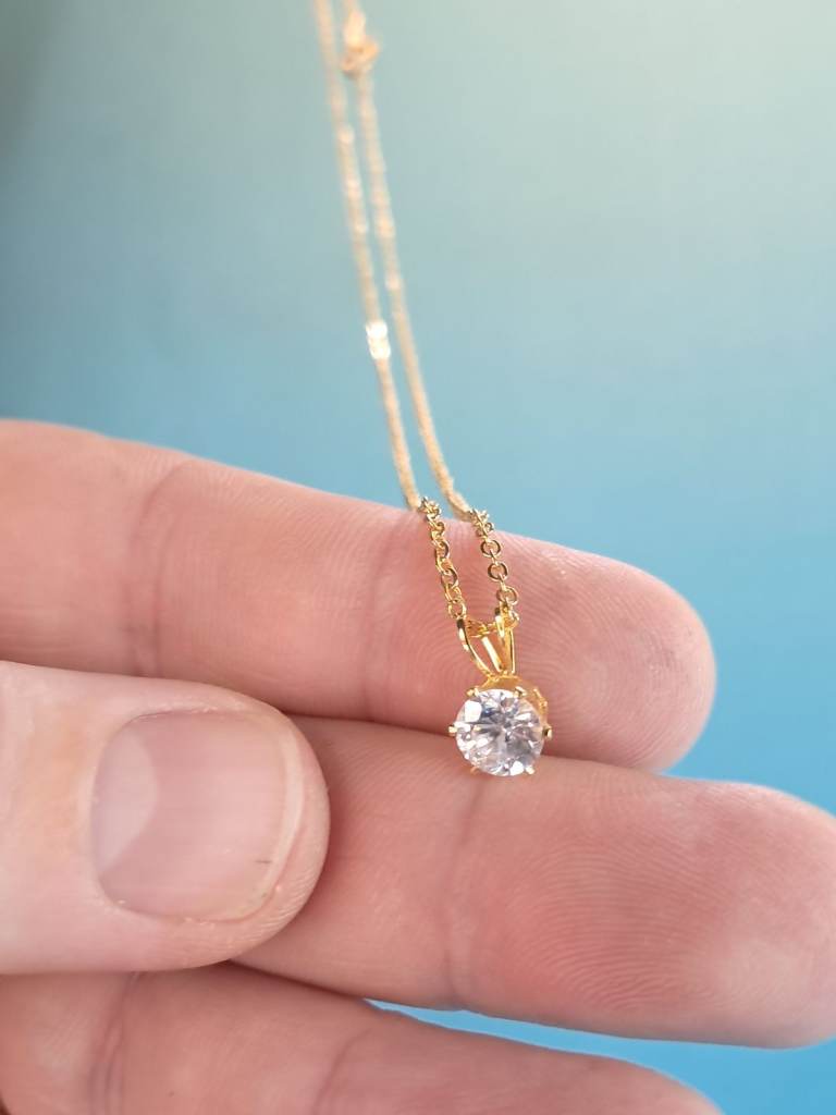 Lovely gold-tone chain necklace with a sparkling cubic zirconia pendant.