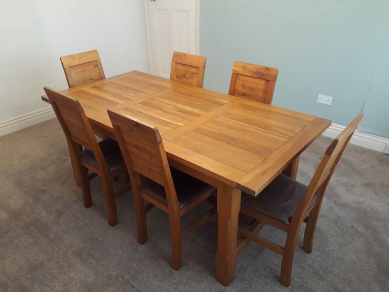 Large wooden heavy dining room table, with 2 x extendable sections and 6 upholstered wooden chairs