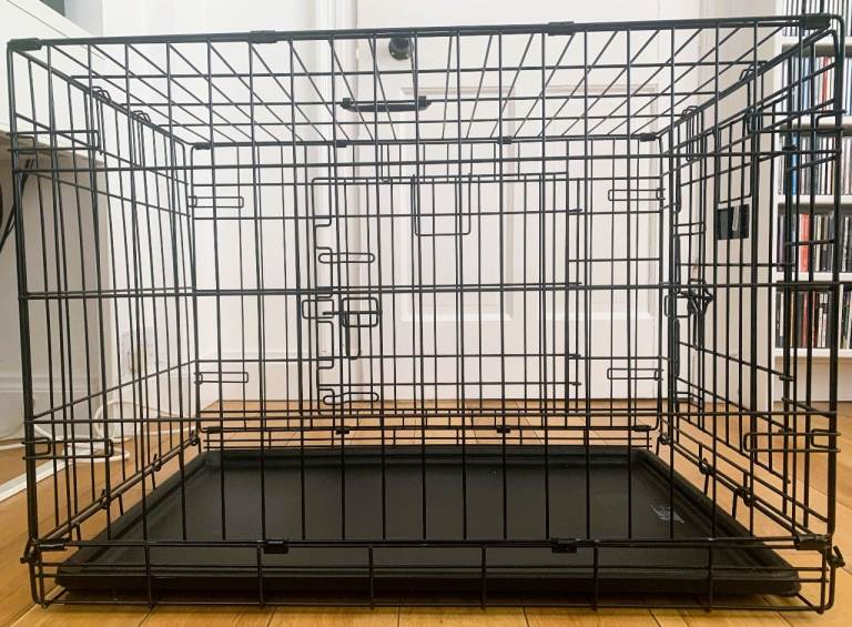 Black metal dog crate with plastic tray