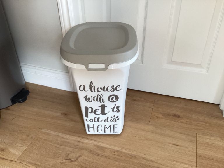 Pet food storage container on wheels with scoop