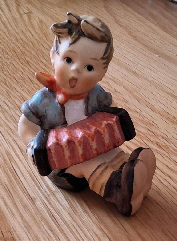 A porcelain boy playing instrument. By Goebel, Germany