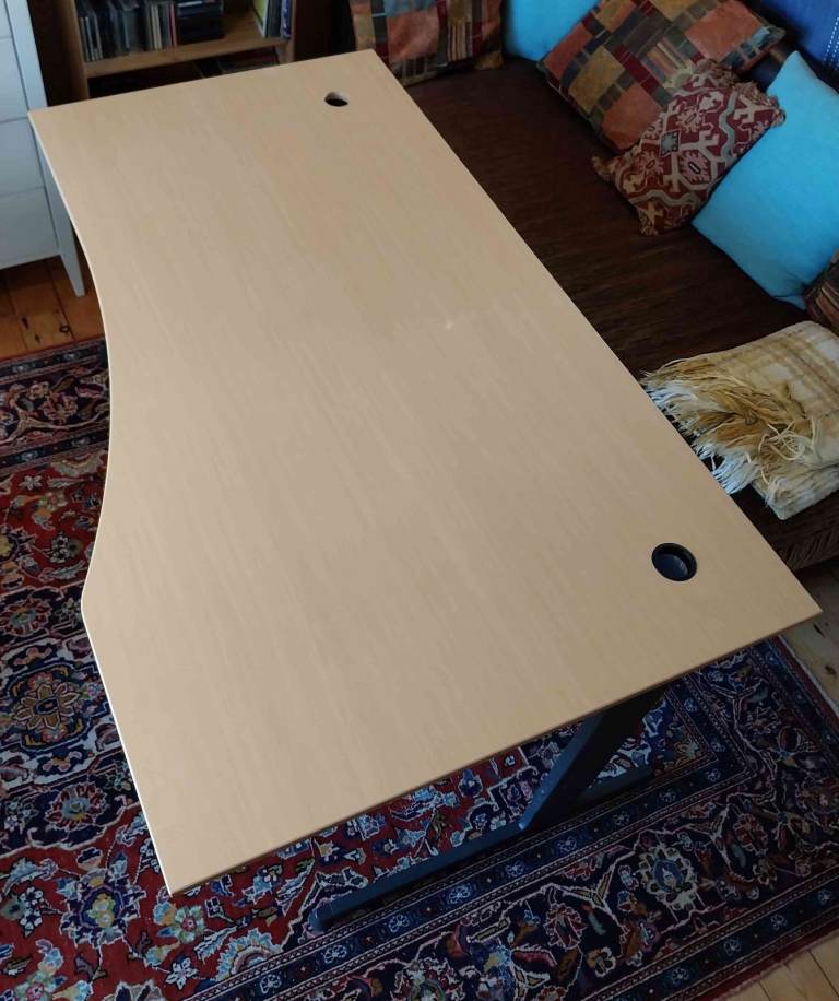 Stylish wooden desk on a lean steel frame, with spacious top and cable routing ducts