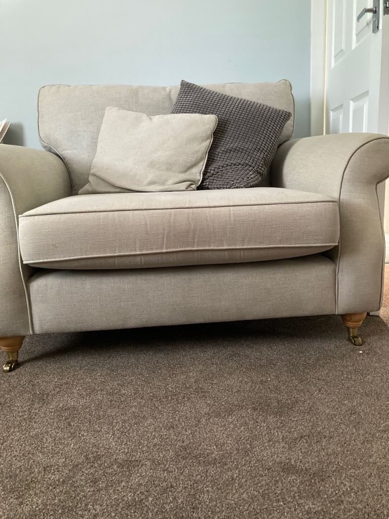 “Next “ two seater sofa on casters at front and legs at back. 
