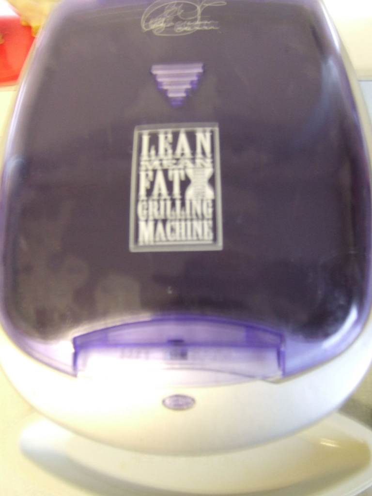 GEORGE FOREMAN GRILLING MACHINE WITH DRIP TRAYS AND BUN/BREAD WARMER COMPARTMENT.