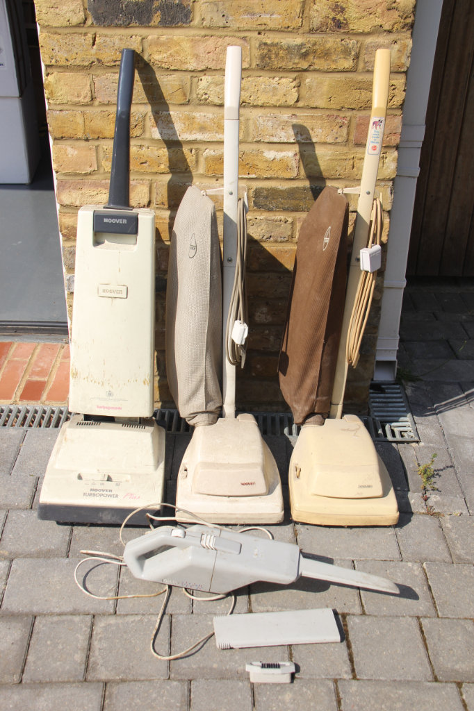 Three old Hoovers and one Goblin hand held cleaner.