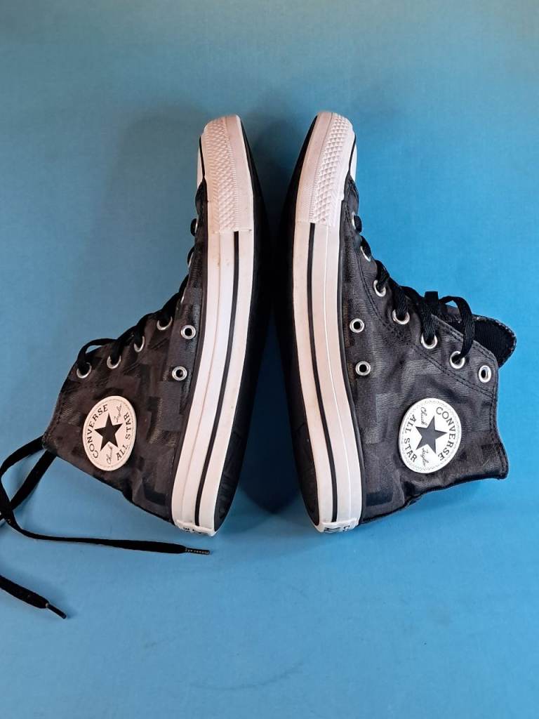 This is a pair of Converse Chuck Taylor All Star high-top trainers in a black and grey colours.