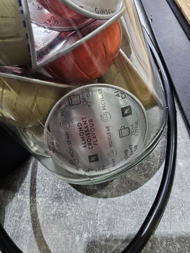 Nespresso veturo pod coffee maker machine in white with Nespresso cups/saucers, storage jar and pods