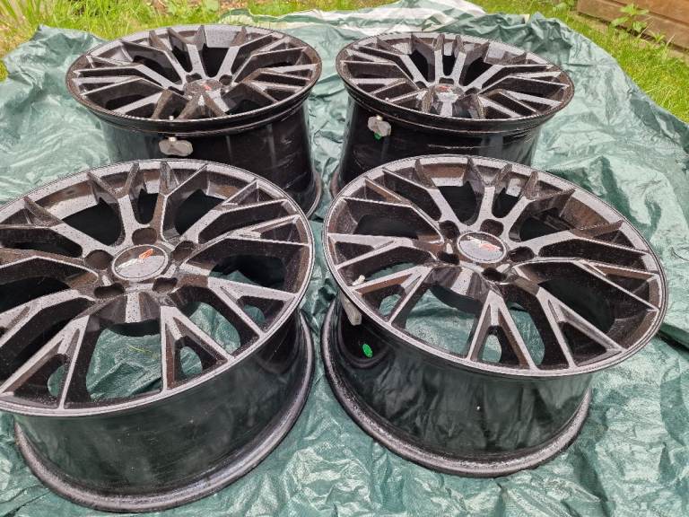 Set of 4 staggered alloy wheels in gloss black finish.