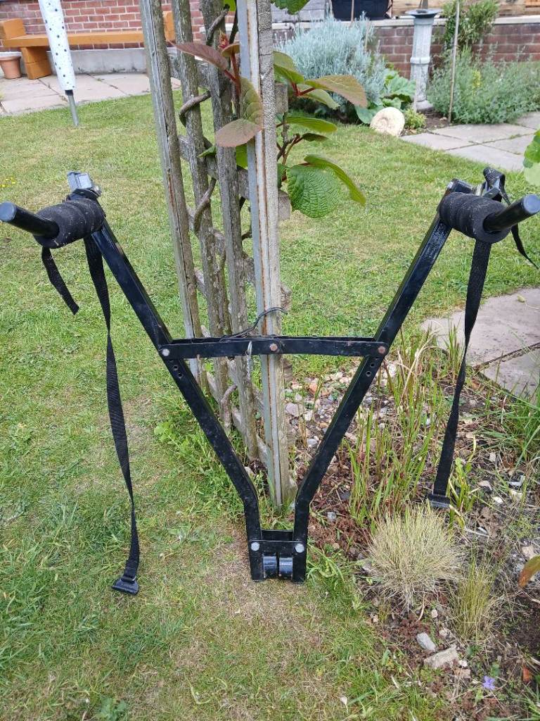 Simple bike carrier that clamps to towbar, carries two bikes.