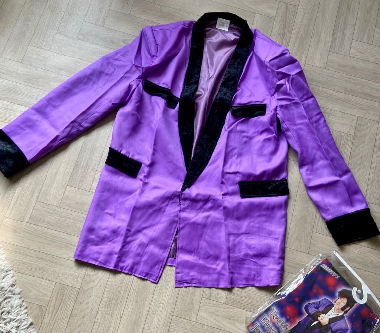 Teddy Boy jacket 1950s. Purple lined jacket with black velour trim/shoulder pads. Smiffy’s One size 