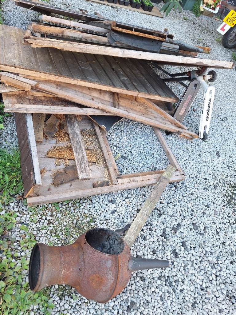 Broken down wood shed, scooters and broken log burner 