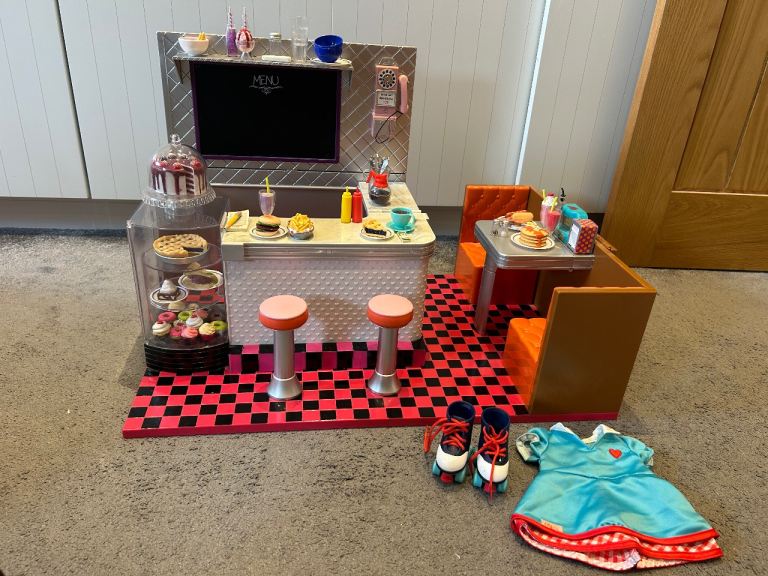 Our generation retro cafe comes with everything in the pictures including outfit and skates.