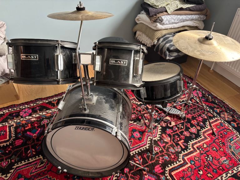 Basic child’s drum kit including stool and sticks.