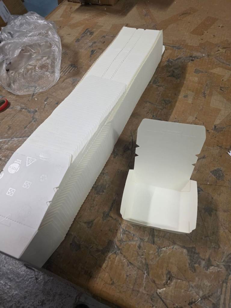 A new still packed a pack of 100 white cardboard cake boxes .