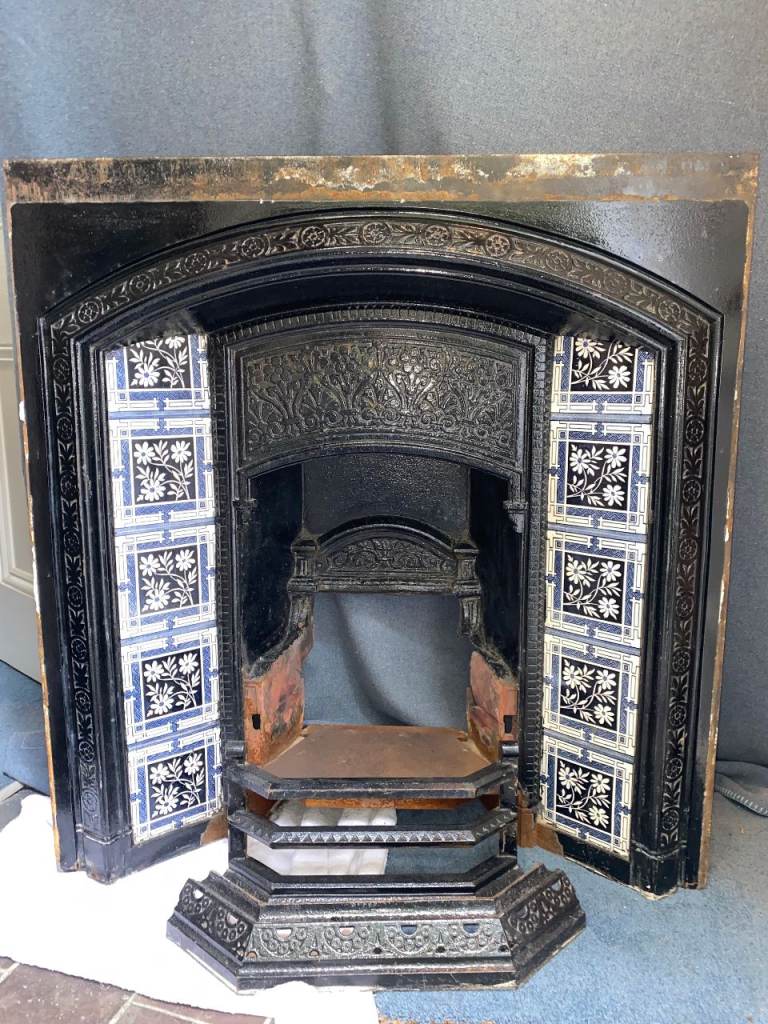 Victorian cast iron fireplace with decorative tiles and fender