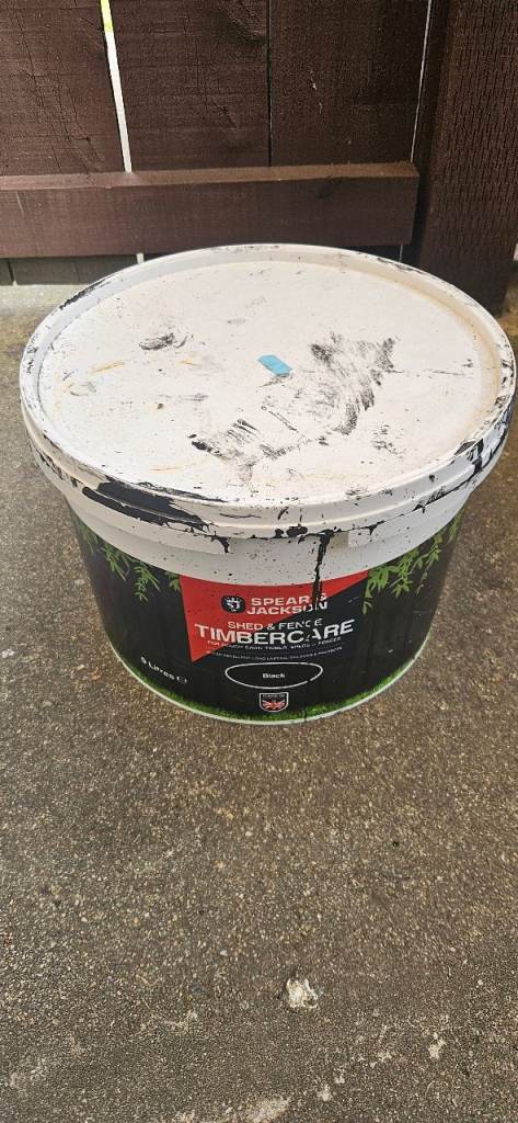 Half pot of fence paint in black 