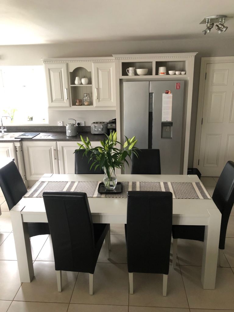 Pale grey solid oak dining room table with six leather chairs