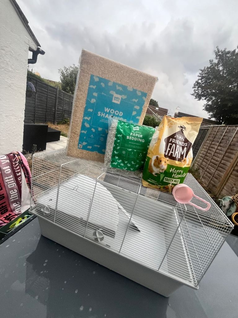 Hamster cage with wood shavings, bedding and food 