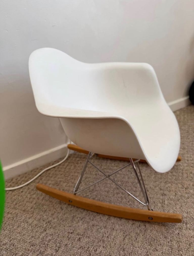 Comfortable white rocking chair with a plastic seat and wooden rocking skids