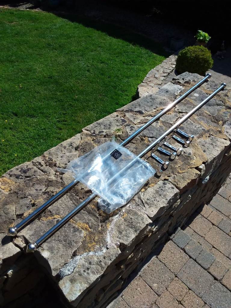 Two chrome curtain poles with brackets and rings. Each 63 inches long.