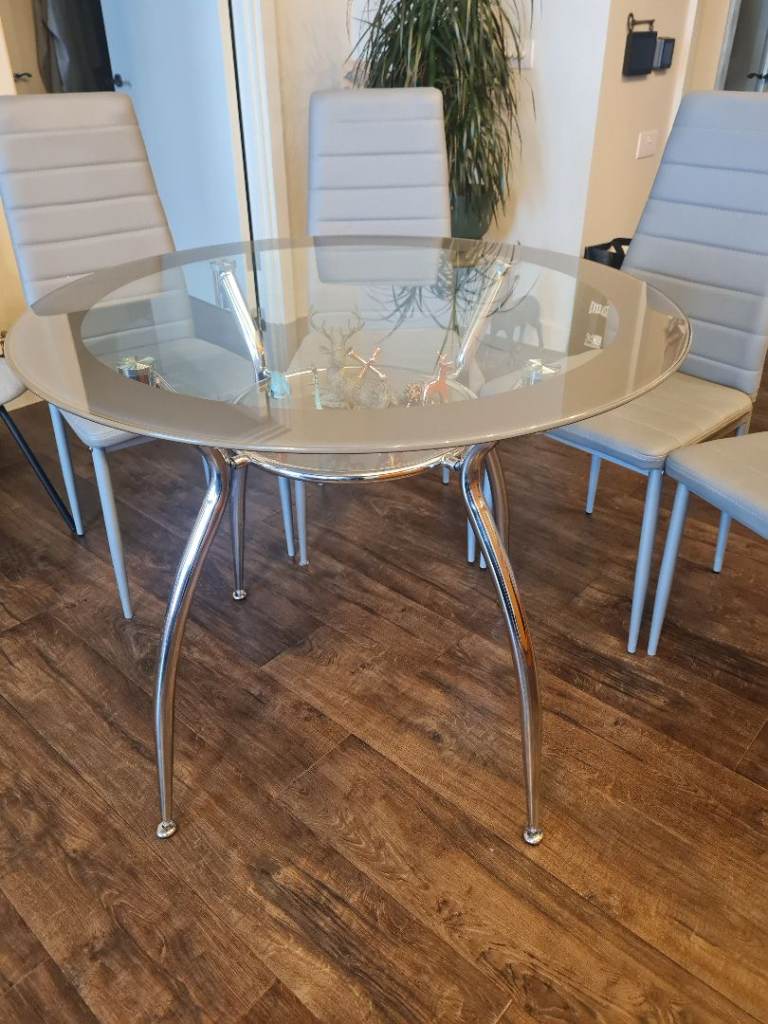 Round glass dining table and four chairs - two tier