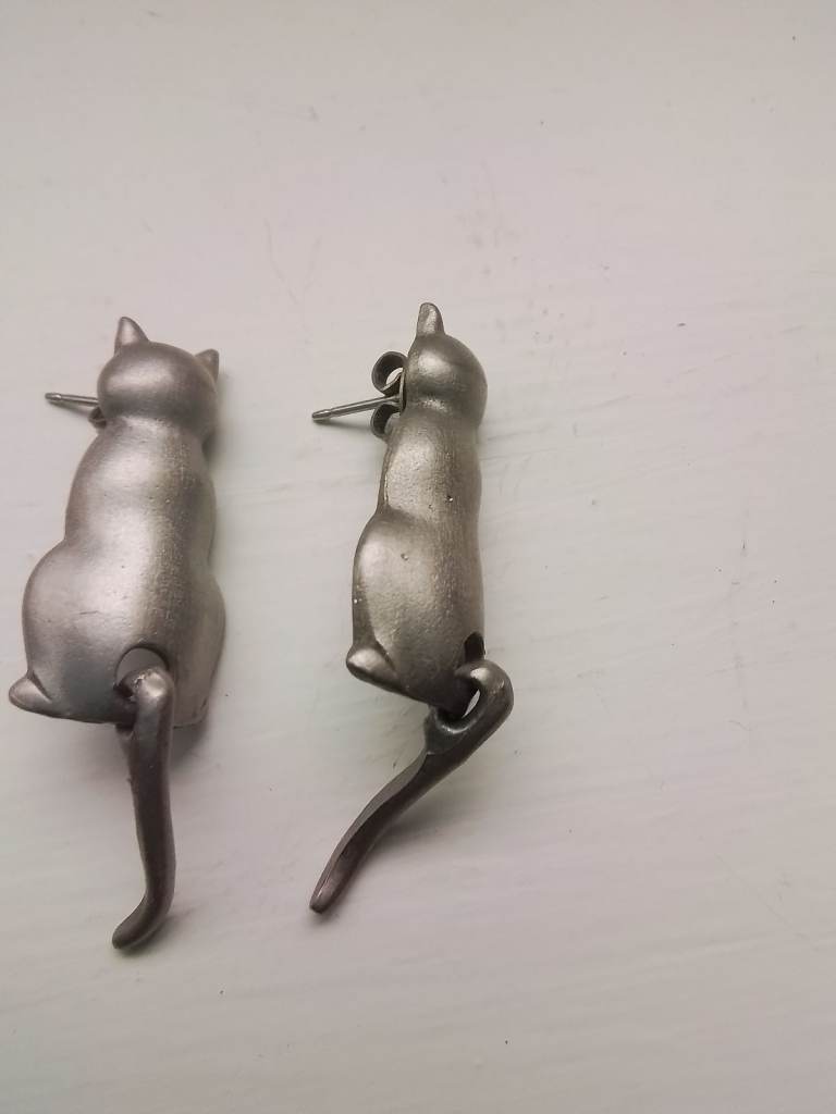 Silver coloured cat earrings with wiggly tails