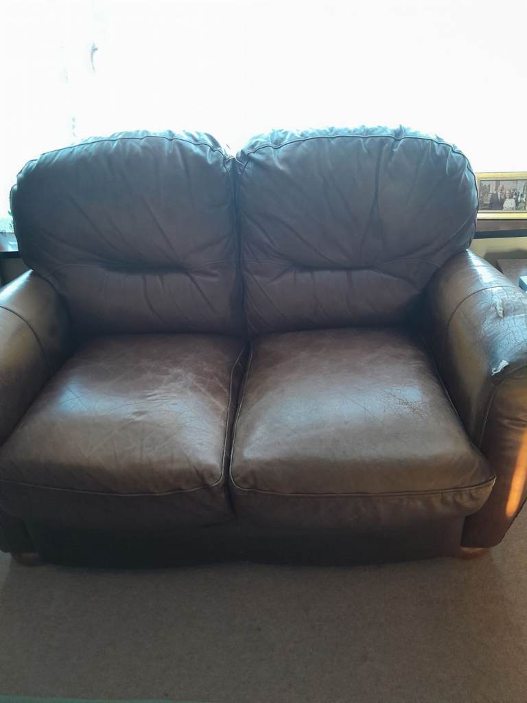 Small brown two seater leather sofa.