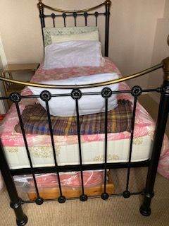 single brass and black metal bed