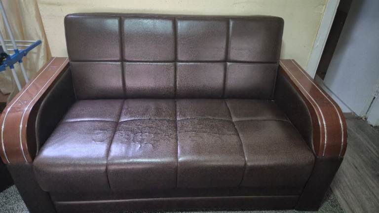 Brown leather two-seater sofa with wooden armrests. 
