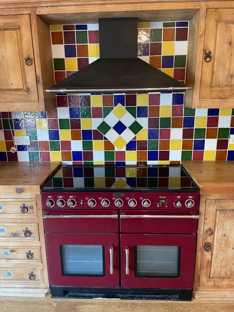 Rangemaster 110 Excel All electric oven with induction hob in red with separate extractor hood.