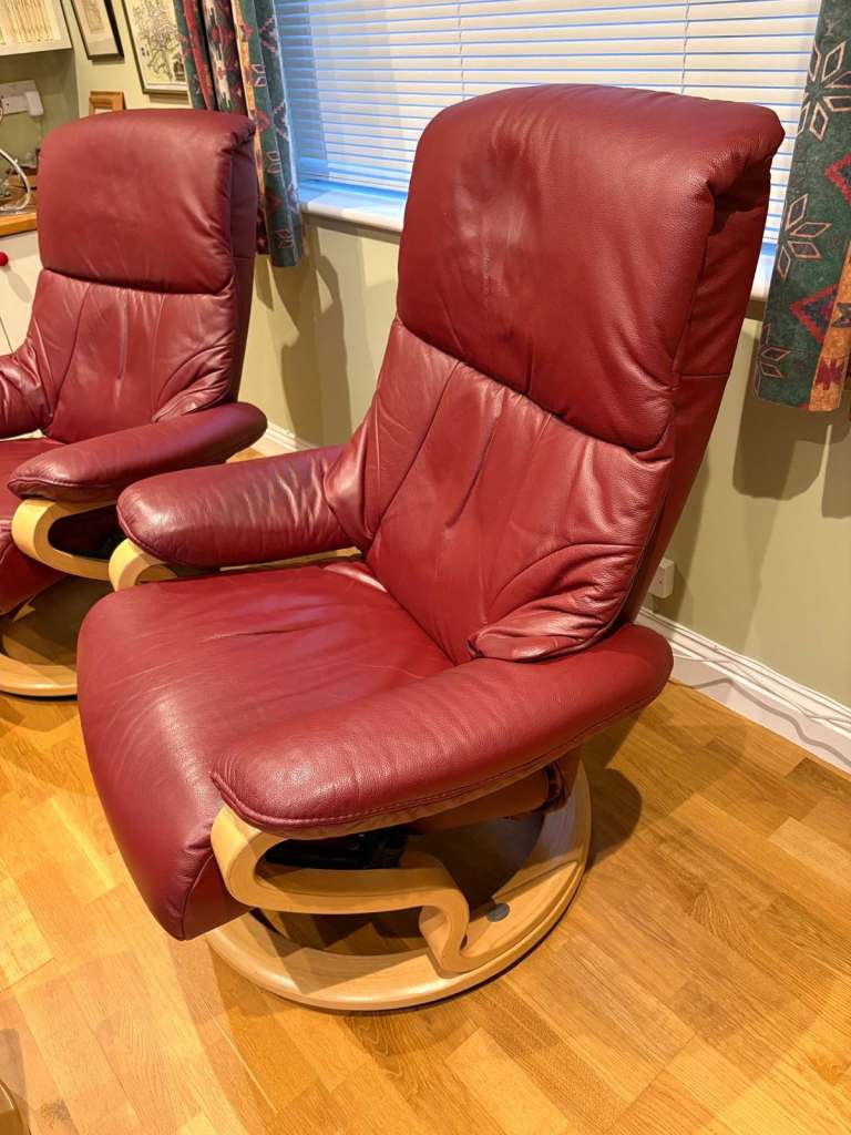 Pair of red leather reclining chairs with foot stools