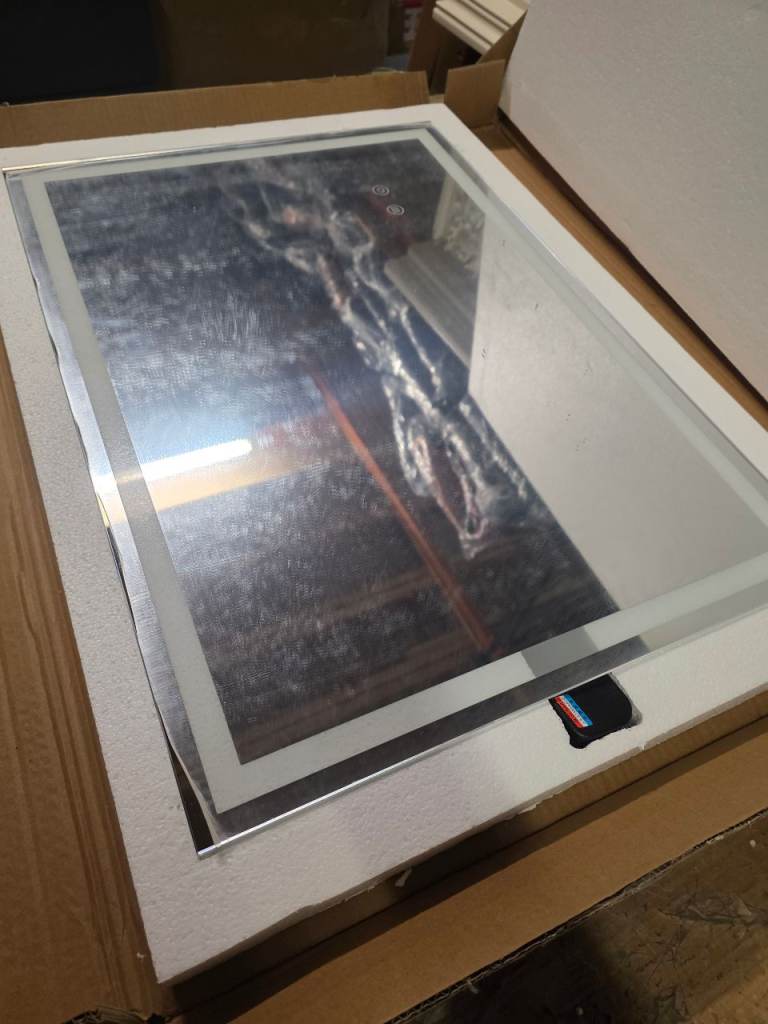 A new still boxed white and clear Wall mirror with electric powered led light .