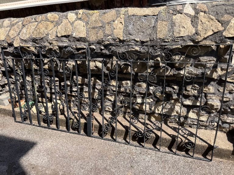 Pair of wrought iron gates. Metal scrolls. Lockable with ground bolt. 250cm W x 105cm H. Driveway.