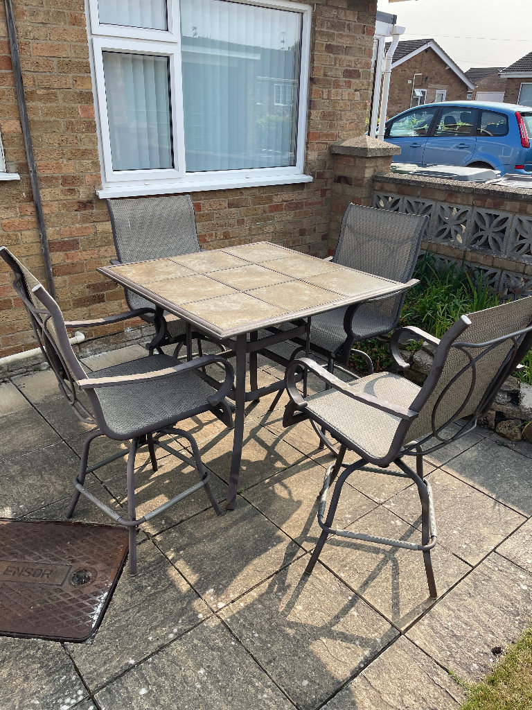 Metal and tiles high table and 4 rotating high chairs with fabric seat and backs.